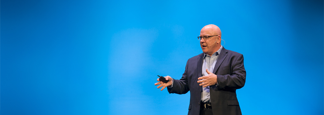 Paul Gibbons speaking on stage